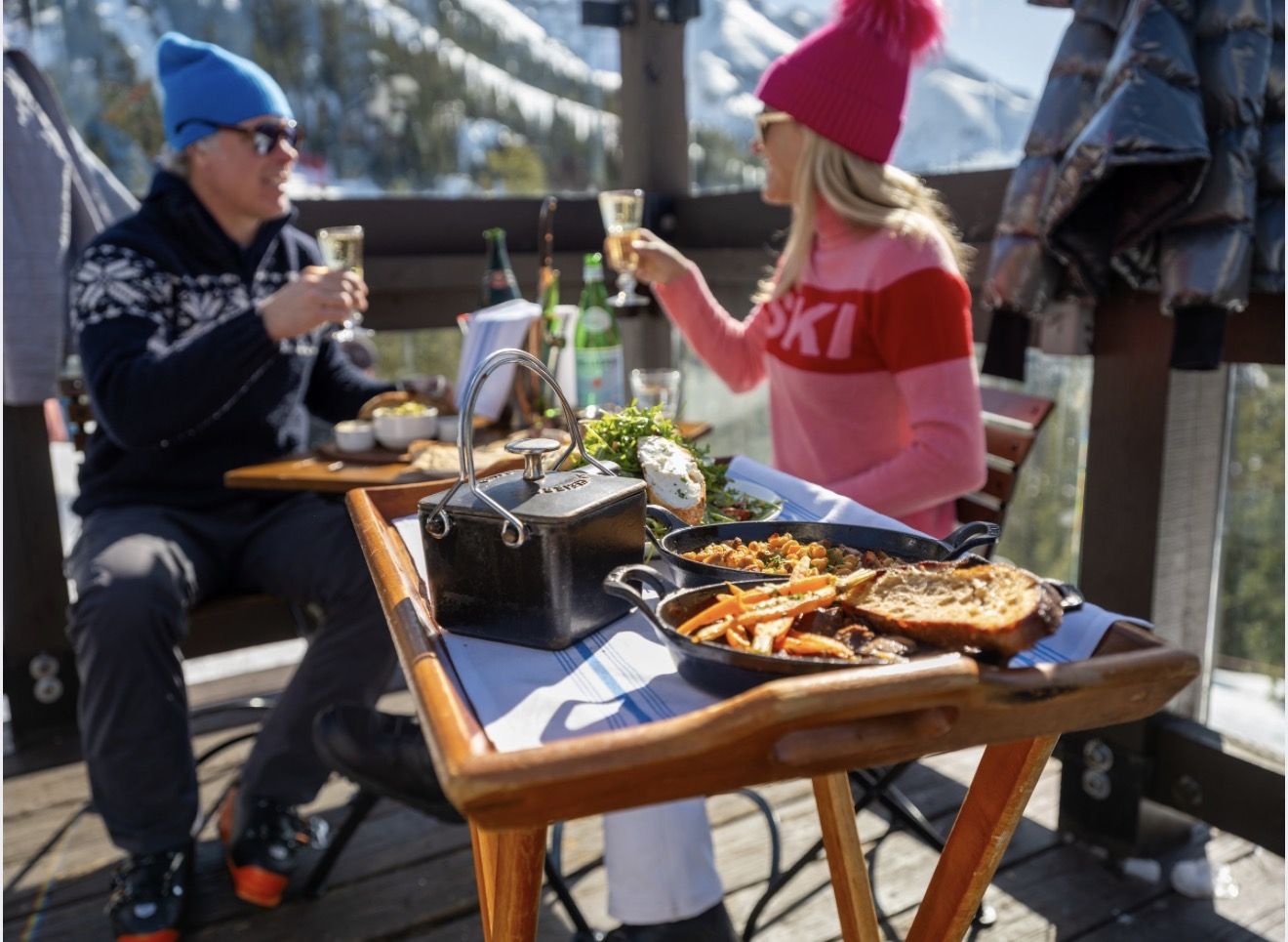 Lunch served on the deck at Bon Vivant, cast-iron dishes and champagne with the mountains behind