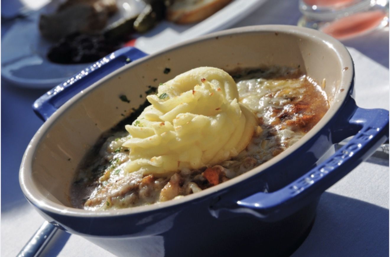 A dish baked and browned under a piped potato topping, served in cast iron