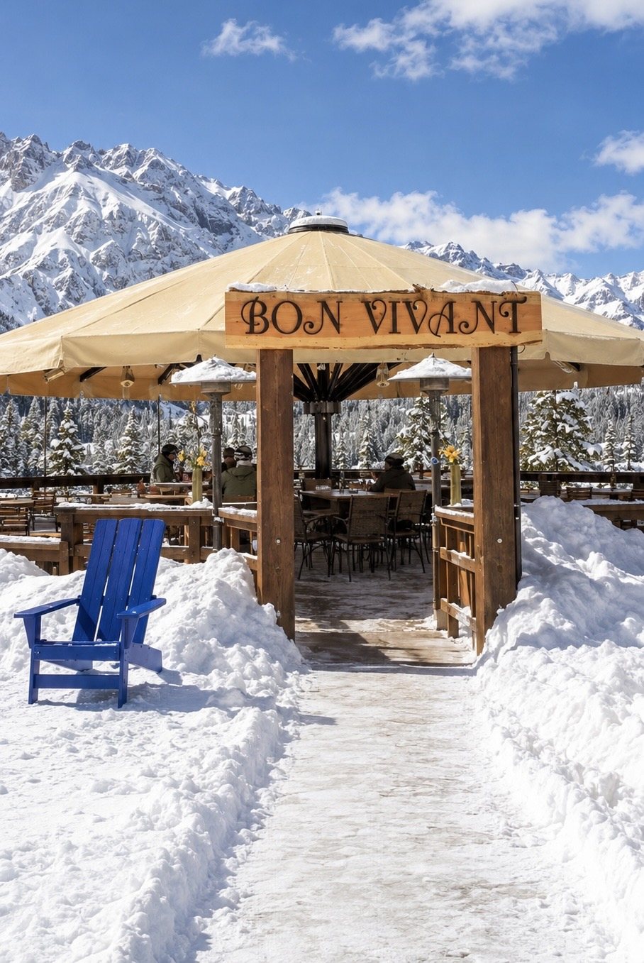 The Bon Vivant deck under its heated umbrella at the top of Lift 5, with the snow-covered peaks of the San Juans behind
